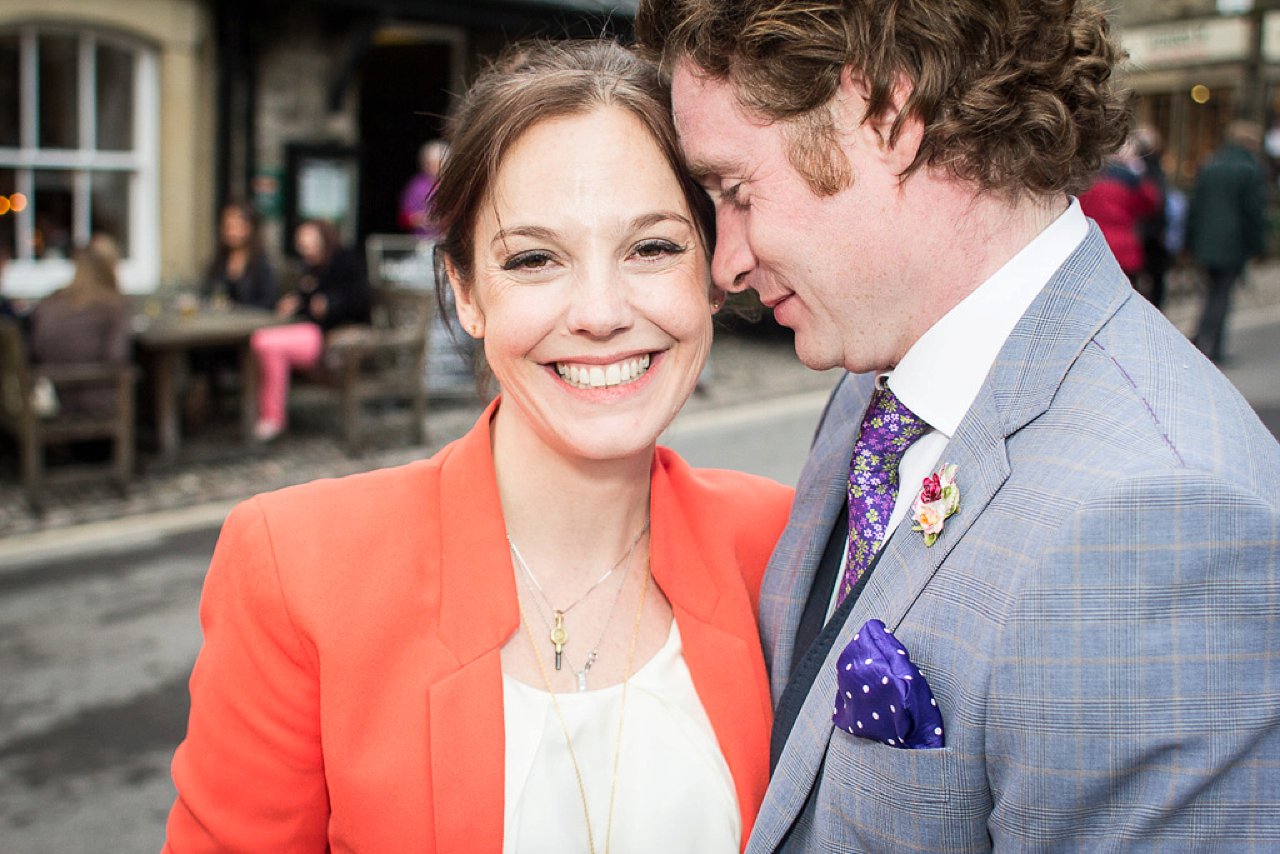 Bride in orange jacket with groom